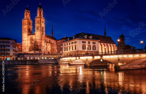 Panorama  image of evening Zurich. Night long exposure image of the Grossmunster Romanesque-style Protestant church in Zurich, Switzerland. Popular travel dectination. © jenyateua