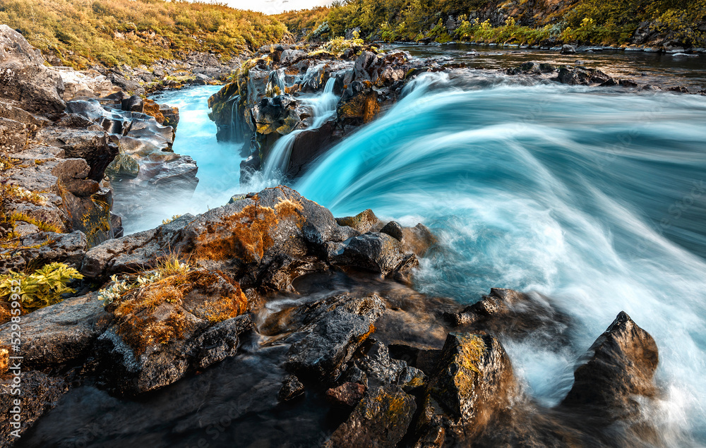 Beautiful waterfall with colorful sky during sunset. Nature landscape of Iceland. Travel is a Lifestyle, concept. Iceland popular place of travel and touristic location.