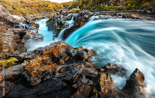 Beautiful waterfall with colorful sky during sunset. Nature landscape of Iceland. Travel is a Lifestyle  concept. Iceland popular place of travel and touristic location.