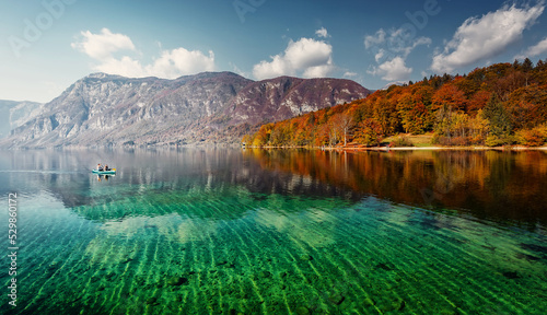 Beautiful sunny landscape. View on mountain lake with crystal clear azure water in Julian Alps. Slovenia. Awesome Autumn landscape. Bohinj Lake. Triglav National Park