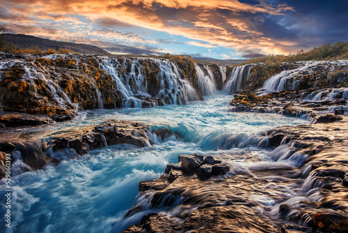 A beautiful river morning with waterfall and sun light. Scenic image of Iceland. Colorful sunset over the Bruarfoss Waterfall with picturesque sky during sunset. Amazing nature of Iceland