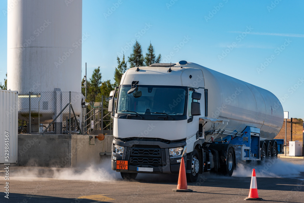 Unloading of a tanker truck with gas, creating a cloud due to condensation and low temperature in transport.