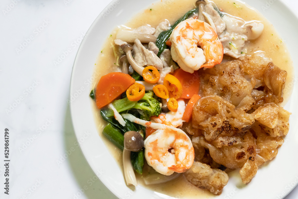 Fried noodles with shrimp and vegetable in gravy sauce with pickled chili in vinegar. Top view on white table background. Fried noodles with shrimp and vegetable in gravy sauce with pickled chili in vinegar. Top view on white table background.