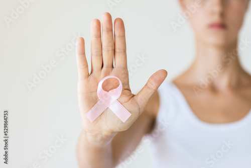 Foto Woman with pink ribbon symbol of breast cancer awareness month.