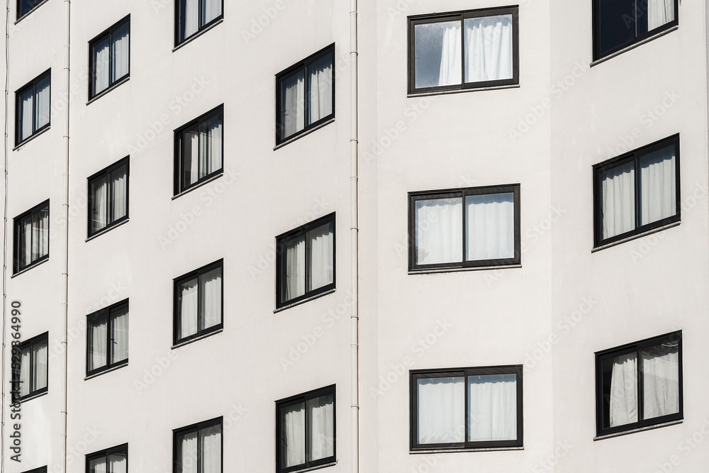 Obraz premium Tall multi-storey building with identical windows.