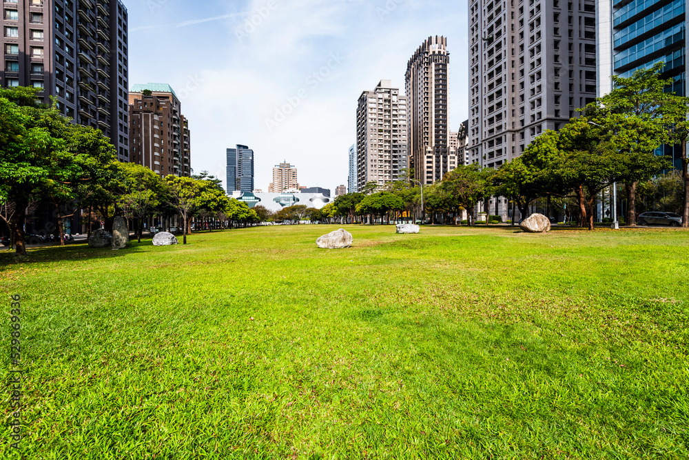 The large area of park space in front of the National Taichung Theater in Taiwan and the landscape of modern buildings on both sides.