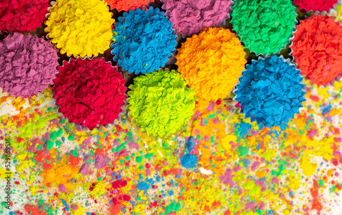 Happy Holi. A colorful festival of colored paints made from powder and dust. Colorful holi powder background. Holiday of bright colors Indian tradition. © Vera