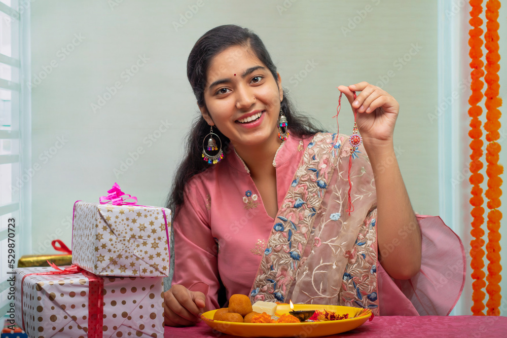 Portrait of a cheerful sister holding Rakhi on the occasion of Raksha Bandhan Portrait of a cheerful sister holding Rakhi on the occasion of Raksha Bandhan