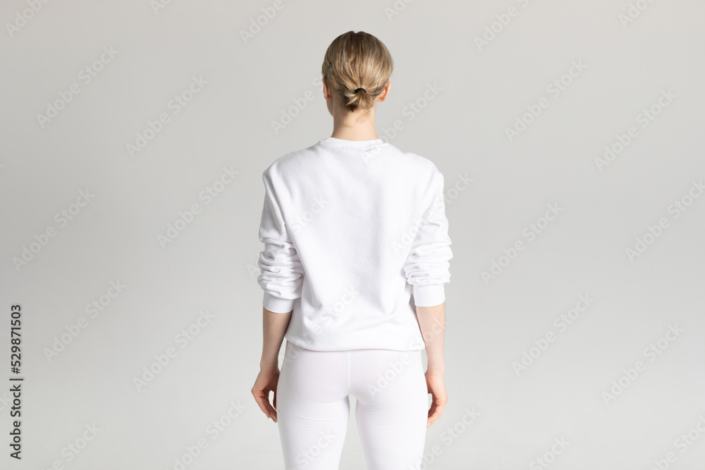 Attractive blonde woman in white sweatshirt and leggings on white background. Mock-up. Attractive blonde woman in white sweatshirt and leggings on white background. Mock-up.