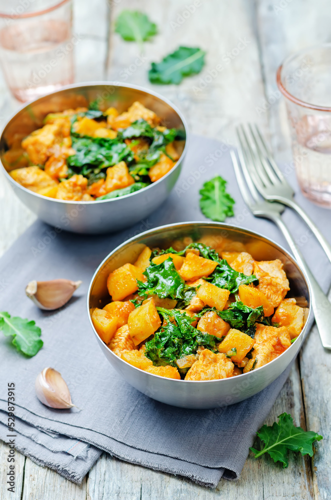 Sweet potato kale chicken stew in a bowl on a wood background Sweet potato kale chicken stew in a bowl on a wood background