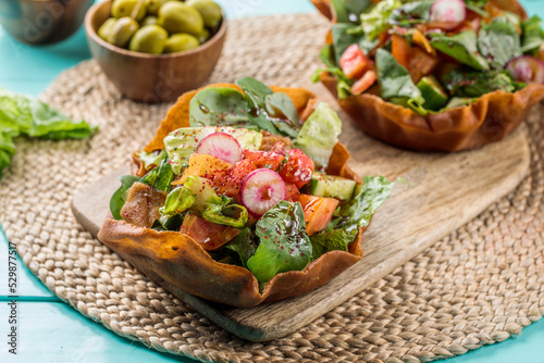 Fattoush served in dish isolated on wooden table side view of middle eastern food