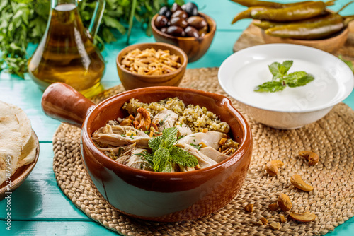 Freekeh Chicken or Freekat Chicken served in dish isolated on wooden table side view of middle eastern food photo