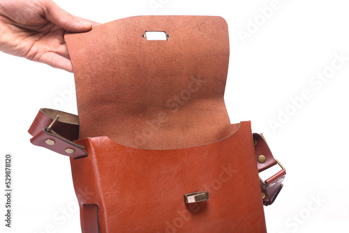 leather bag on white background, opens the bag with her hand, 