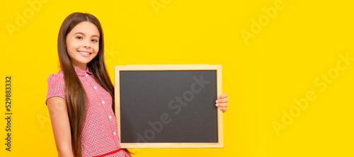 cheerful teen girl hold blackboard. child advertising. back to school. Horizontal isolated poster of school girl student. Banner header portrait of schoolgirl copy space. © Olena