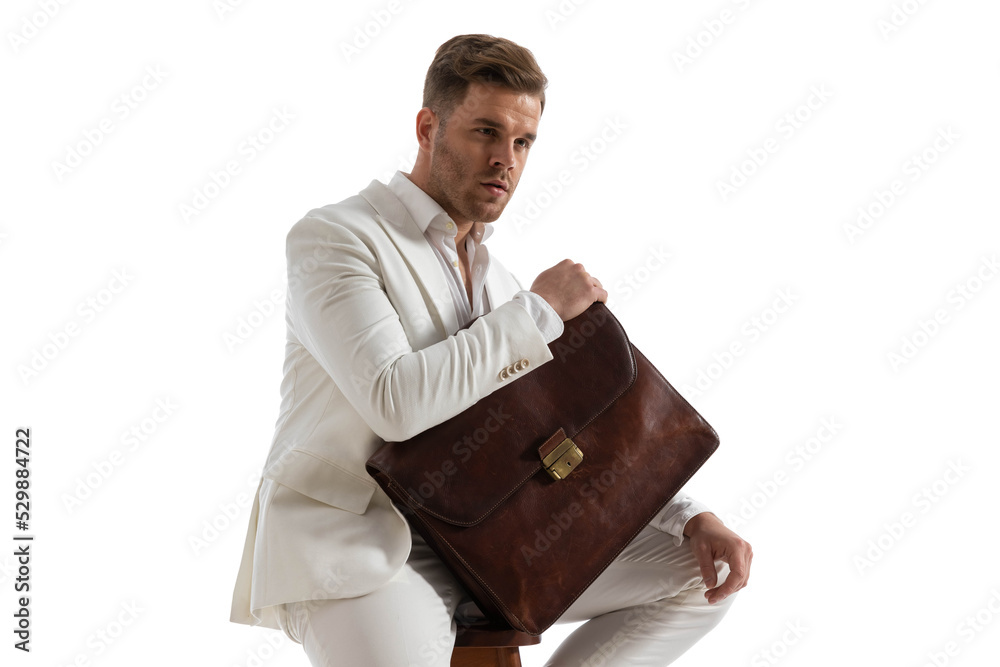attractive businessman holding briefcase while looking away