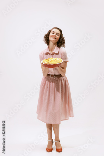 Portrait of beautiful woman holding apple pie isolated over white background. Wife duties