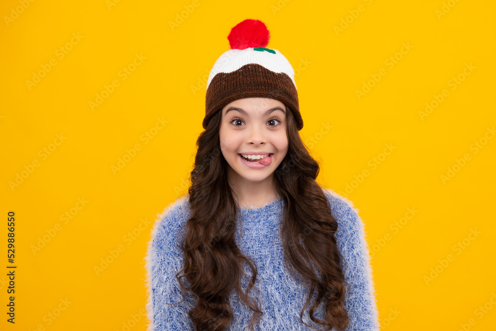 Funny face. Fashion happy young woman in knitted hat and sweater having fun over colorful blue background.