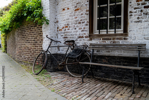 Mood pictures of ambiance in the small town oud-rekem.  Old bike and a little bench to take a break.  Toerism in the Limburg.  Promotional picture for biking in belgium flanders, mood picture photo