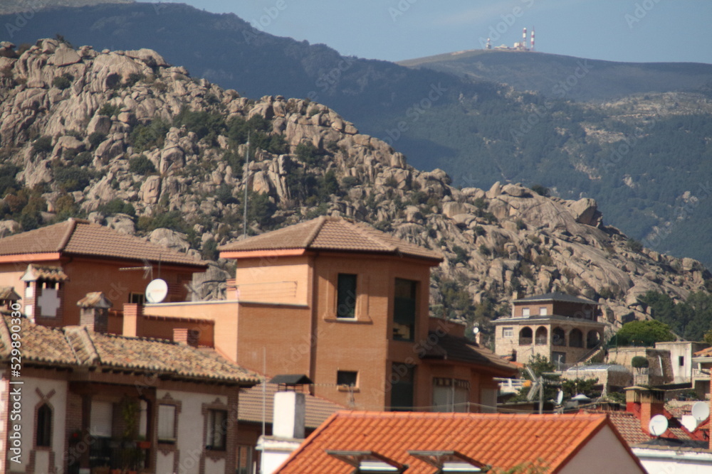 Paisaje casas pueblo Manzanares el Real con montañas de la pedriza al fondo. Madrid, España