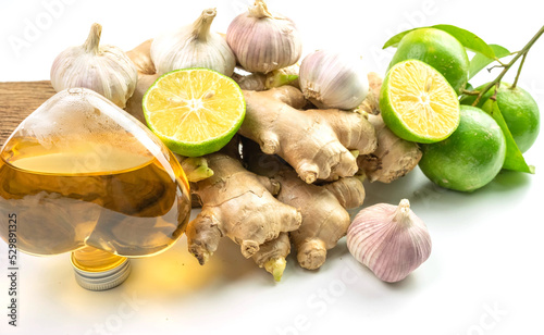 Ginger herb with ginger oil and lemon and garlic isolated on white background.