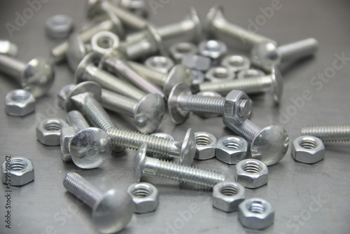 A set of various nuts, bolts, screws on the background of a steel plate. Locksmith business.