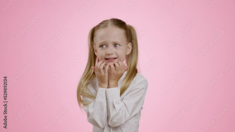 Kids stress. Nervous little girl feeling stressed, touching her chin, being afraid of something, pink background Kids stress. Nervous little girl feeling stressed, touching her chin, being afraid of something, pink background