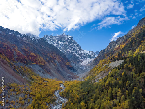 Beautiful, delightful autumn view from a drone of the mountains, the river, the Chalaadi glacier on a sunny day. Very beautiful autumn landscape of the mountains photo