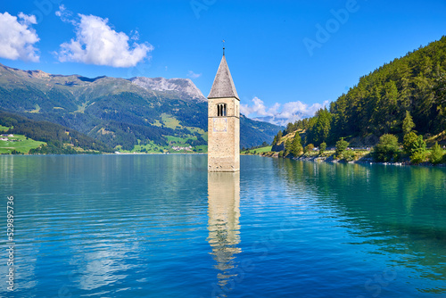 Fotobehang bell tower that comes out of the lake of resia, italy