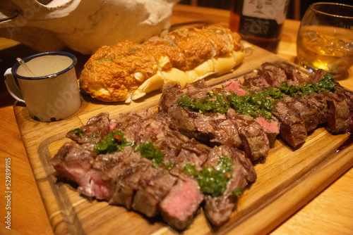 Carne fatiada com pão italiano ao lado em ambiente texano photo