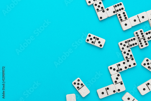 Domino pieces on turquoise blue background with copy space. Flat lay minimalist photo of some domino bones.