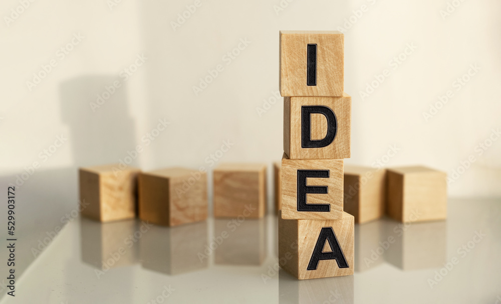 The inscription IDEA on wooden cubes isolated on a light background, the concept of business and finance. The inscription IDEA on wooden cubes isolated on a light background, the concept of business and finance.