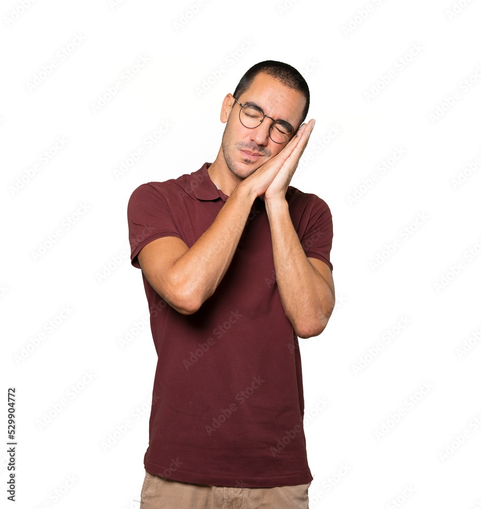 Relaxed young man making a gesture of sleep Relaxed young man making a gesture of sleep