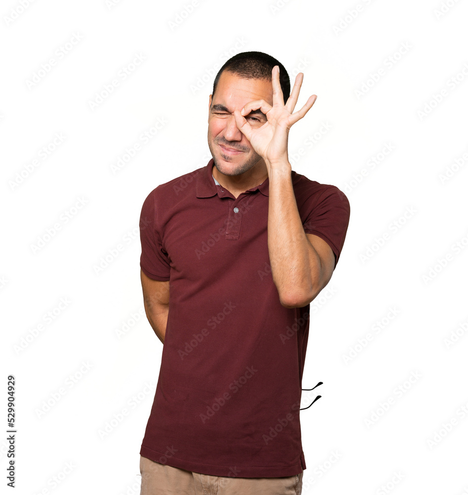 Happy young man using his hands like a binoculars Happy young man using his hands like a binoculars