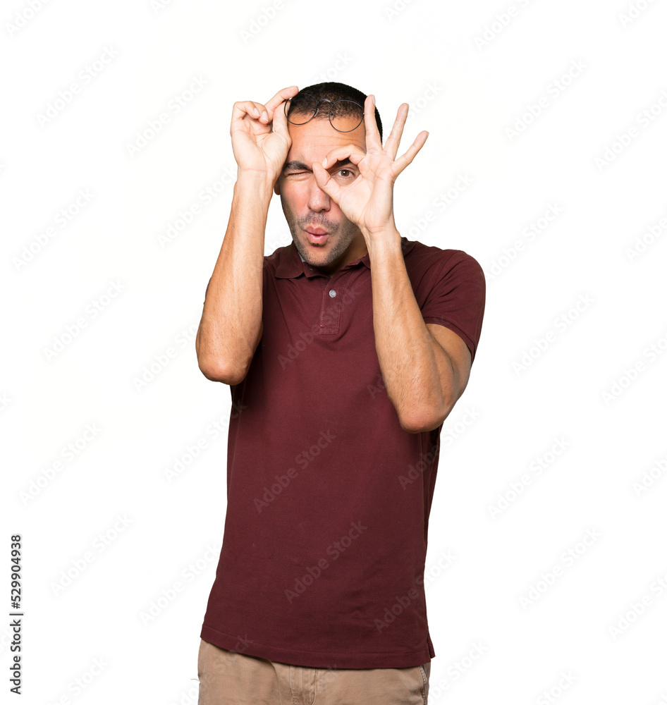 Happy young man using his hands like a binoculars Happy young man using his hands like a binoculars