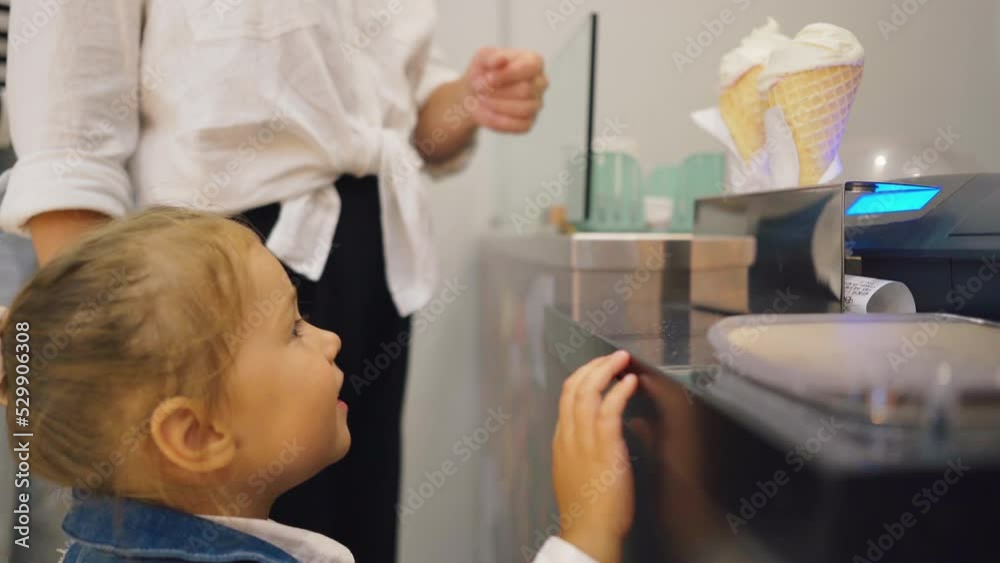 A little girl chooses and buys ice cream A little girl chooses and buys ice cream