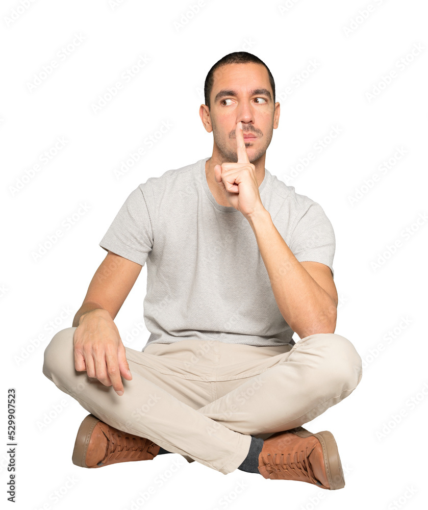 Serious young man asking for silence gesturing with his finger Serious young man asking for silence gesturing with his finger