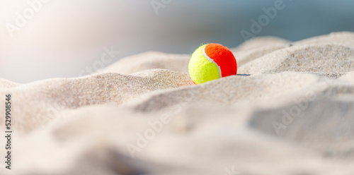 Beach tennis ball on the sandy beach. Summer sport concept. Horizontal sport theme poster, greeting cards, headers, website and app © Augustas Cetkauskas