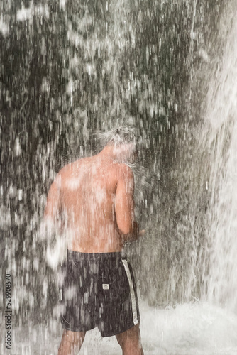 A man standing under a waterfall in Morocco photo