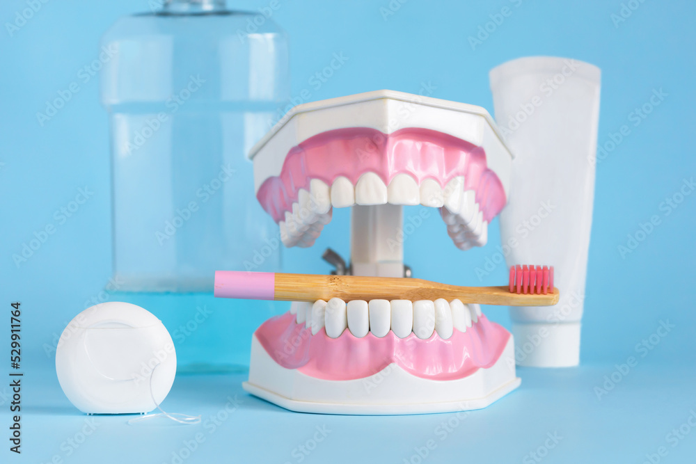 tooth clear in jaw with bamboo toothbrush, floss, paste, rinse in blue