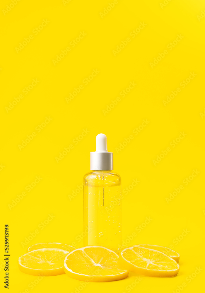 Vitamin C formula ampoule. Serum in transparent bottle with lemon on bright yellow background. Beauty and health concept. Mockup for your design with copy space.