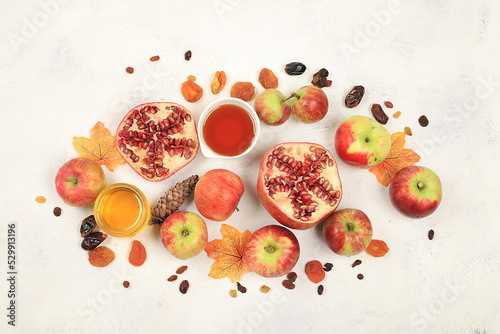Top view of jewish holiday rosh hashan,honey,apples,pomegranates,flowers,dried fruits on stone table top,space for text,with copy space,hello autumn and thanksgiving day concept,