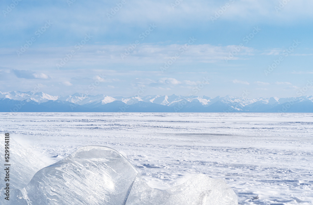 Winter landscape with ice hummocks glittering in the sun and mountains of Lake Baikal in Siberia at sunset. Natural background. Winter landscape with ice hummocks glittering in the sun and mountains of Lake Baikal in Siberia at sunset. Natural background.