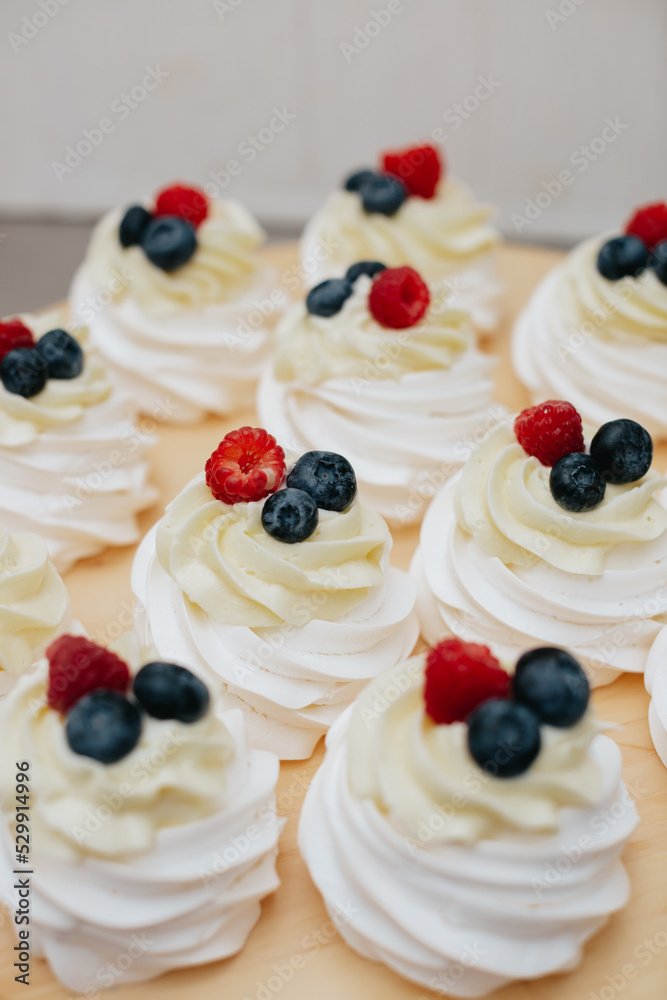 Dessert meringue with raspberry and blueberry on a wooden board. Dessert pavlova with fruits. Dessert meringue with raspberry and blueberry on a wooden board. Dessert pavlova with fruits.