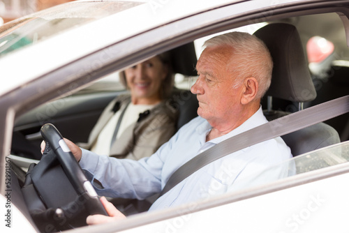 Caucasian senior couple sitting in car. Old man sitting on driver's seat.