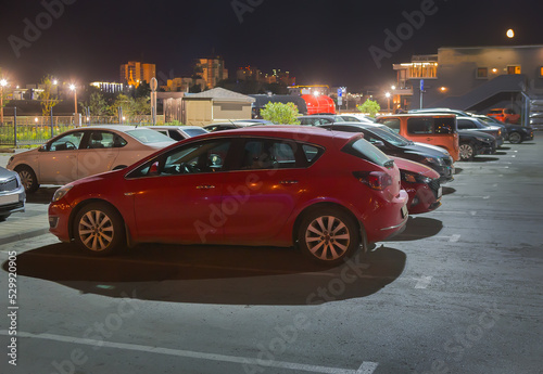 Cars at night in an illuminated parking lot © Yuri Bizgaimer