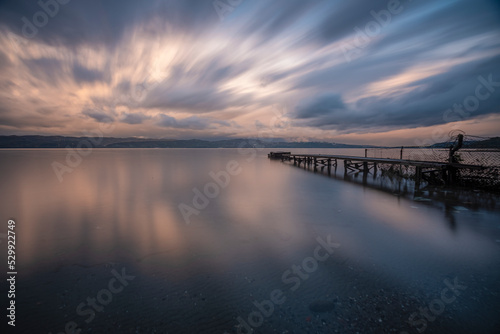 Long exposure reflection of a pier, beautiful colorful clouds and iron pier at sunset time long exposure shot and movement feeling concept
