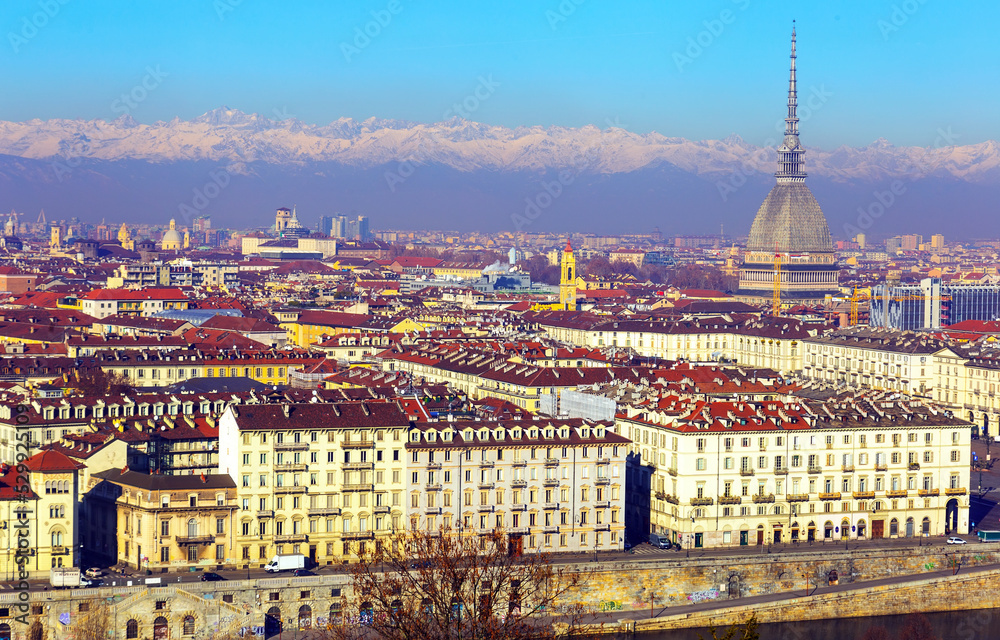 View of Turin center with Mole Antonelliana tower on background with snow-capped Alps, Italy