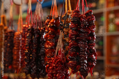 Bunches of different delicious churchkhelas at market, closeup. Space for text photo