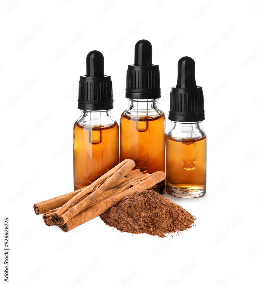 Bottles of natural essential oil, dry cinnamon sticks and powder on white background Bottles of natural essential oil, dry cinnamon sticks and powder on white background