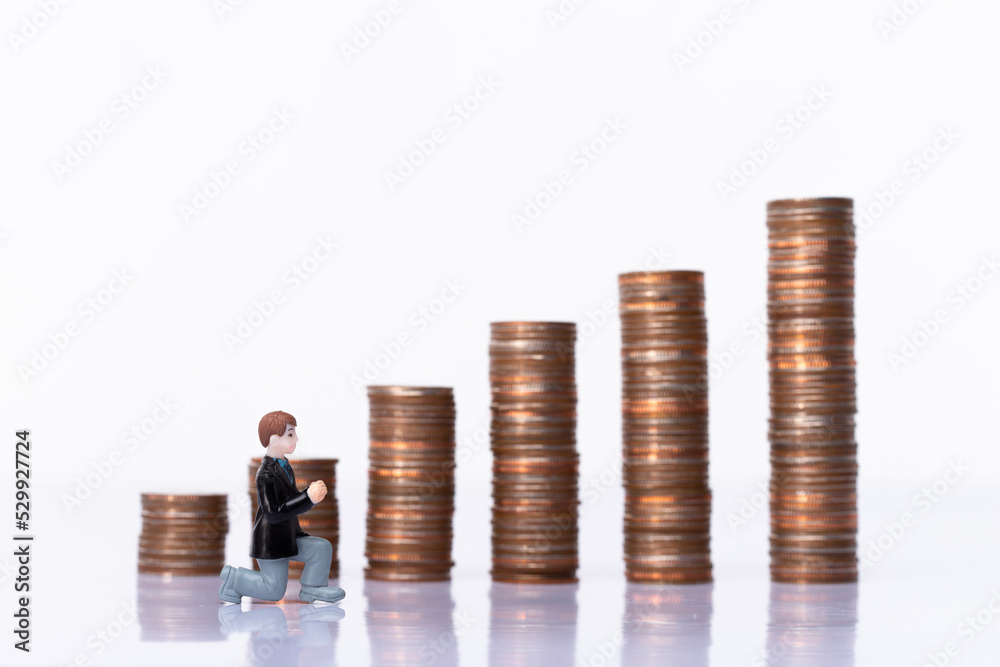 Miniature small doll of couple lovers propose for marriage with romantic valentine moment with background of stack coin as saving money in isolated white. Metaphor concept trade love money Miniature small doll of couple lovers propose for marriage with romantic valentine moment with background of stack coin as saving money in isolated white. Metaphor concept trade love money